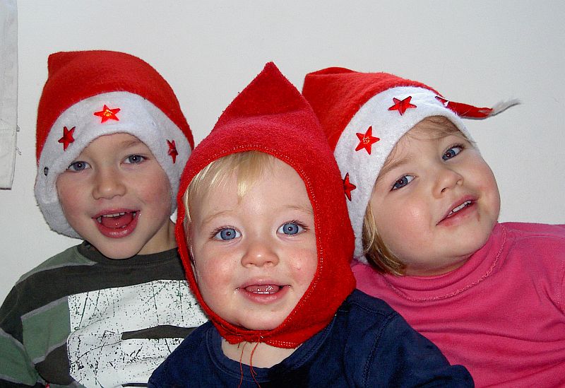 Oskar Vogel und Geschwister tragen rote Kopfbedeckungen. Fotograf unbekannt
